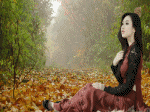 cô gái áo dài đỏ đen ngồi trên đống lá ngắm lá vàng rơi